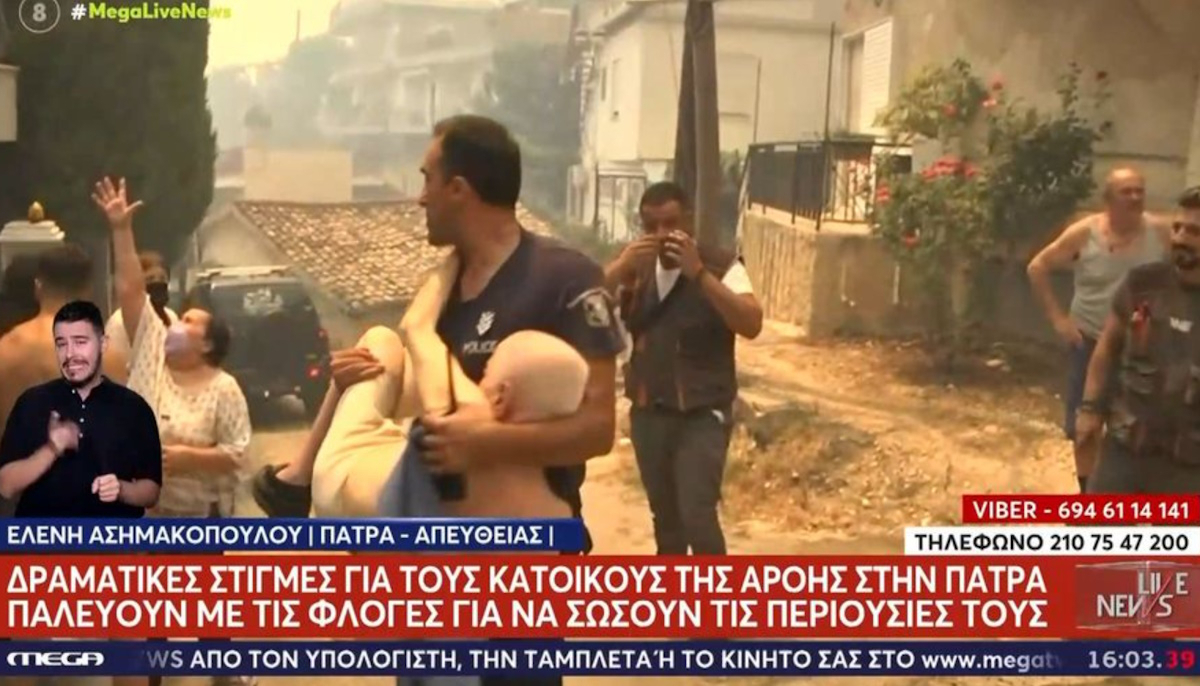 Φωτιά στην Πάτρα: Ανατριχιαστικό πλάνο με αστυνομικό να κρατά στην αγκαλιά του ηλικιωμένο